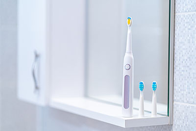 Ultrasonic electric toothbrush with interchangeable nozzles in bathroom at home. Oral hygiene, dental and gum health, healthy teeth. Dental products